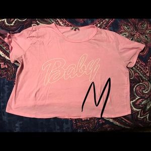 Pink crop top with word “baby” printed on front.